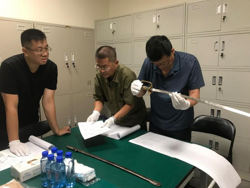 专家评估鉴定现场（图中文物为抗日战争时期冼恒汉在百团大战中缴获敌人的马刀）.png